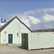 The toilet block at Poppit Sands with the Blue Flag flying behind it.