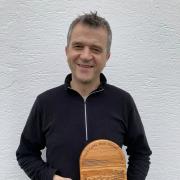 Emyr James, with the award he designed and carved in memory of his mother, Mair Garnon James