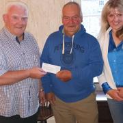 Councillor Keith Evans receives the cheque on behalf of Glangwili hospital from Keith Evenden and Teresa Brunt.