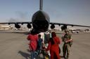 Afghan civilians board a military plane at Kabul airport