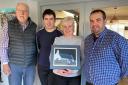 Carys James, Stepside Agriculture Contractors, Gwbert Road, Cardigan, with the painting of Mwnt Church. Also pictured are Daniel James, Rhodri James and artist Wynne Melville Jones.