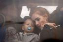 A woman holds her baby inside a bus as they leave Kyiv, Ukraine, Thursday, Feb. 24, 2022.