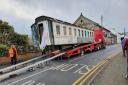 All aboard! The old railway carriage sets off on its final journey.