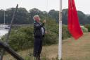 Phil Hutchings, Chairman of St Dogmaels Community Council, raises the Red Ensign. PHOTO: Photo: Mick Kendall.