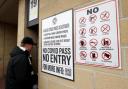 A Swansea City fan enters the team's stadium next to a notice about requirements for a Covid pass (Bradley Collyer/PA)
