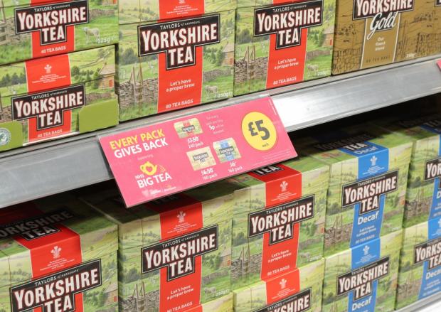 Tivyside Advertiser: Teabags on shelves and a Every Pack Gives Back label at a Morrisons store (Morrisons)