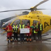 Calfyn Jones hands over a cheque for £4,500 to the Wales Air Ambulance crew.
